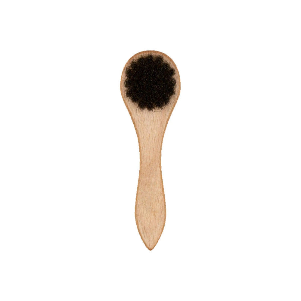 New Era Wooden Cap Brush, front view showing a natural wood handle with curved edges and black bristles set into the round head, designed for maintaining and cleaning cap surfaces effectively.