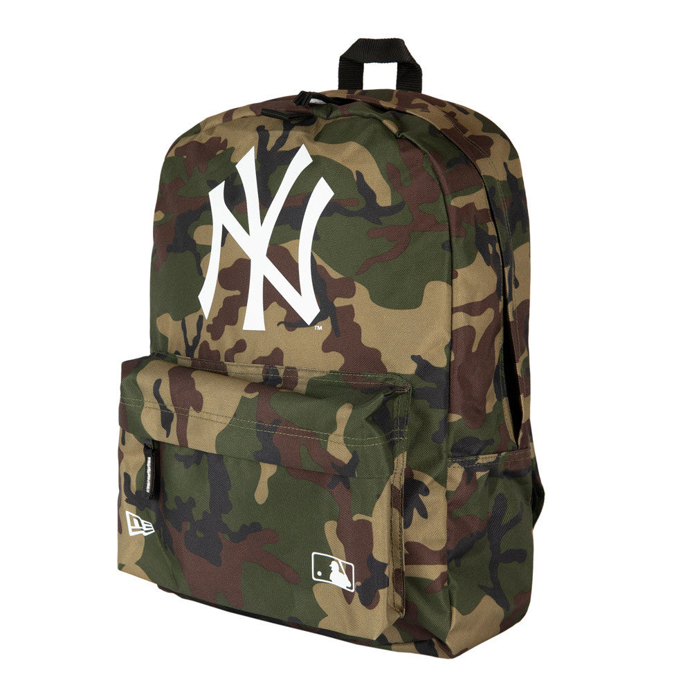 New York Yankees Woodland Camo Stadium Backpack, front view showing a large white raised Yankees logo centred on the camouflage pattern, a front pocket with a zip, and a raised New Era logo at the lower left corner.