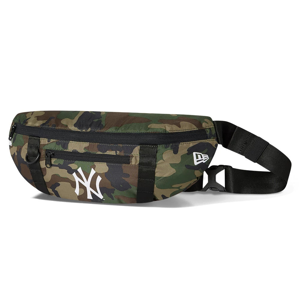 New York Yankees Camo Waist Bag, side view showing a camouflage design with a white debossed New Era logo near the attachment point of the black adjustable strap, a zip closure along the top and a white New York Yankees logo on the front.