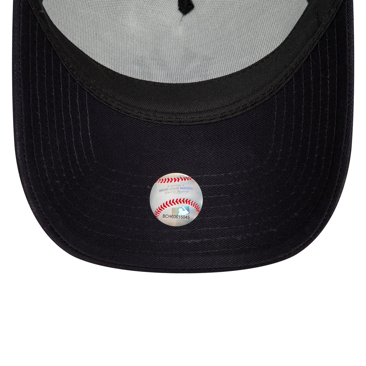 New Era New York Yankees Team Colour White A-Frame Trucker Cap, inside view showing the black undervisor and the round MLB sticker with a baseball graphic centred on the underside of the visor.