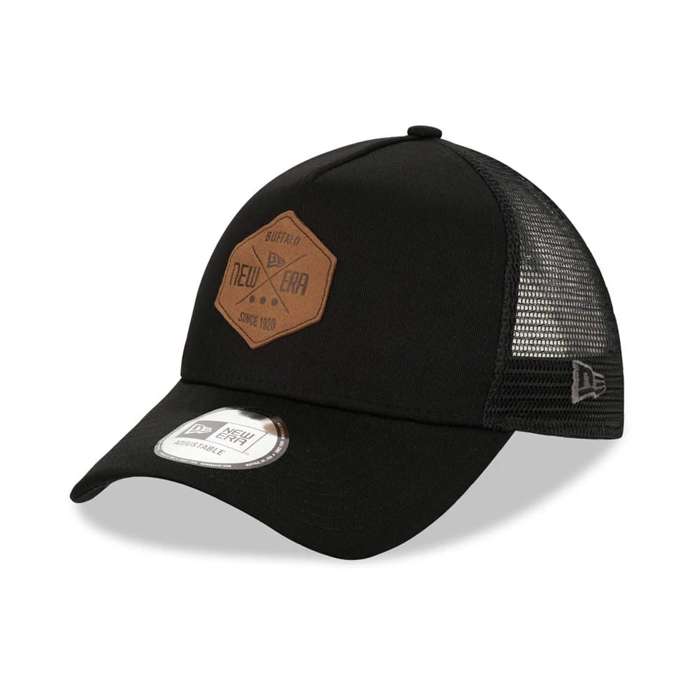 New Era Patch Black A-Frame Trucker Cap, three-quarter view showing a brown hexagonal logo patch on the front panel, curved visor with a New Era 9FORTY size sticker, and mesh back panels with a New Era flag logo on the left side.