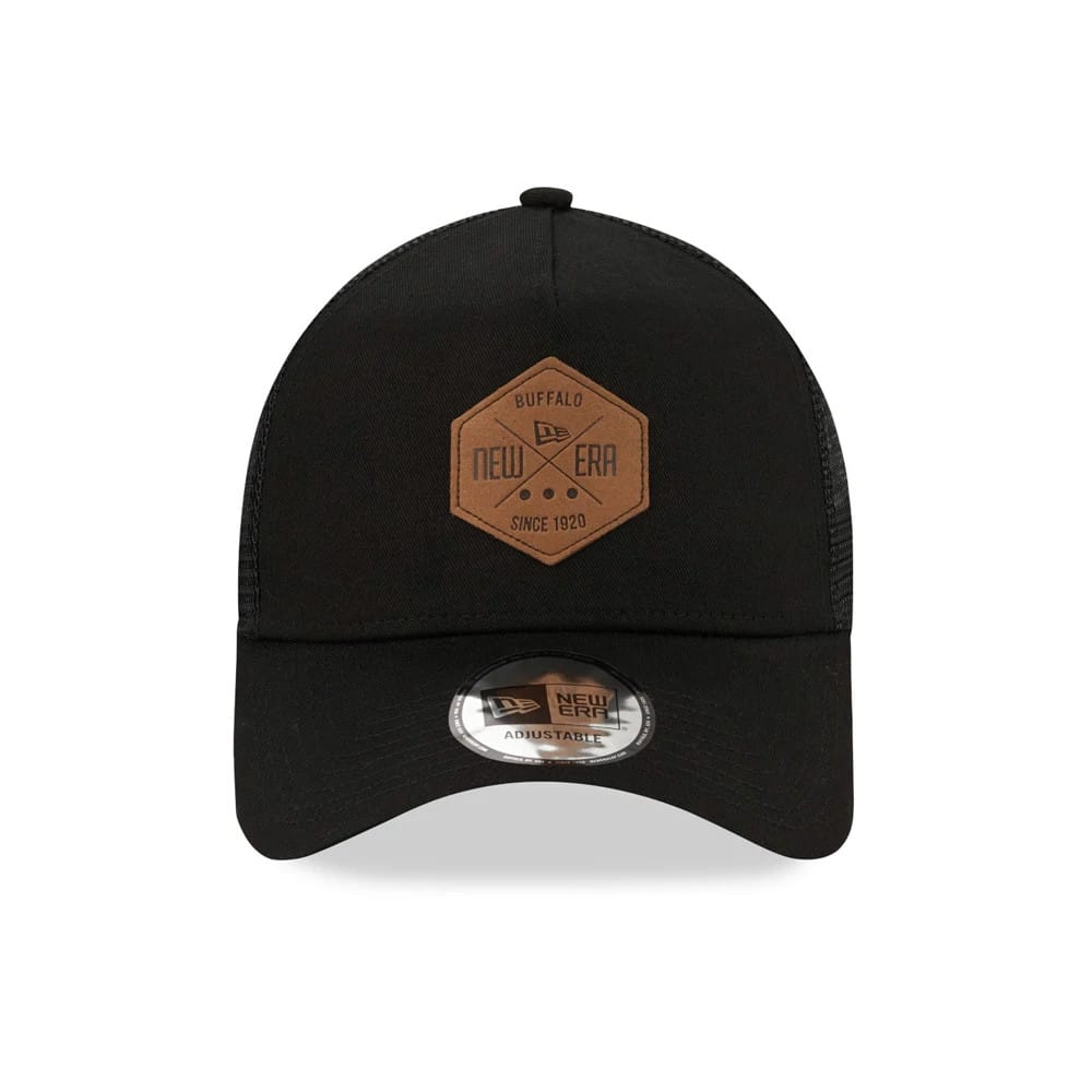 New Era Patch Black A-Frame Trucker Cap, front view showing a brown hexagon patch with the New Era logo and lettering on the centre of the black crown, paired with a curved visor and a New Era 9FORTY size sticker.