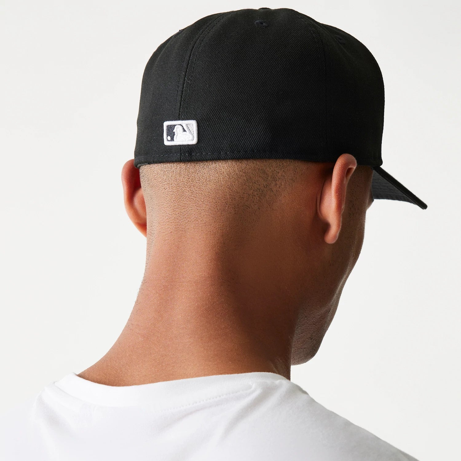 Chicago White Sox Authentic On Field Game Black New Era 59FIFTY Cap, rear view on a model showing the white embroidered MLB Batterman logo at the centre back of the black crown, paired with a white T-shirt.