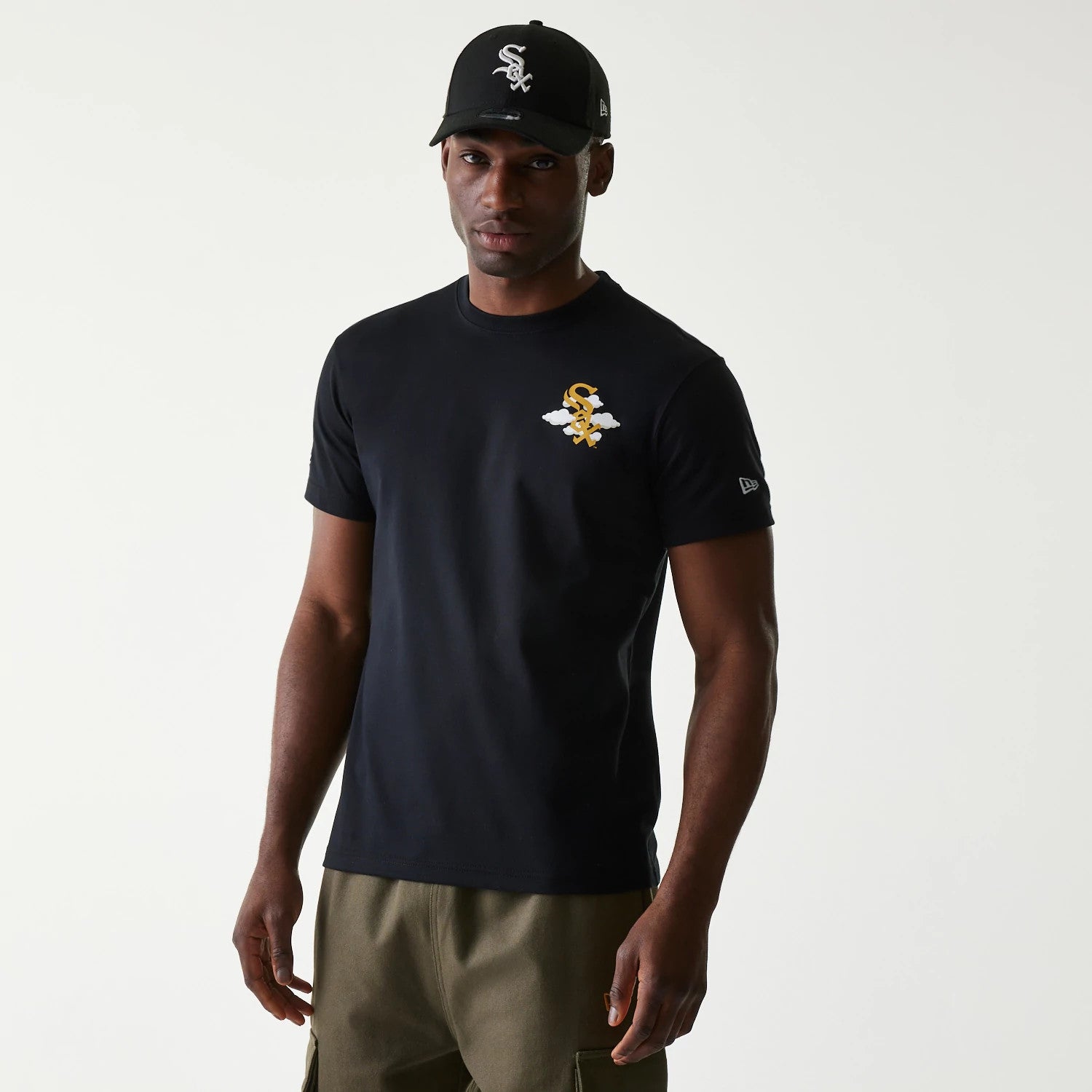 Chicago White Sox MLB 59FIFTY Pack Cloud Black T-Shirt, on-model view showing a black t-shirt with a white and gold winged logo on the chest, paired with a black cap featuring a raised white team emblem on the front.