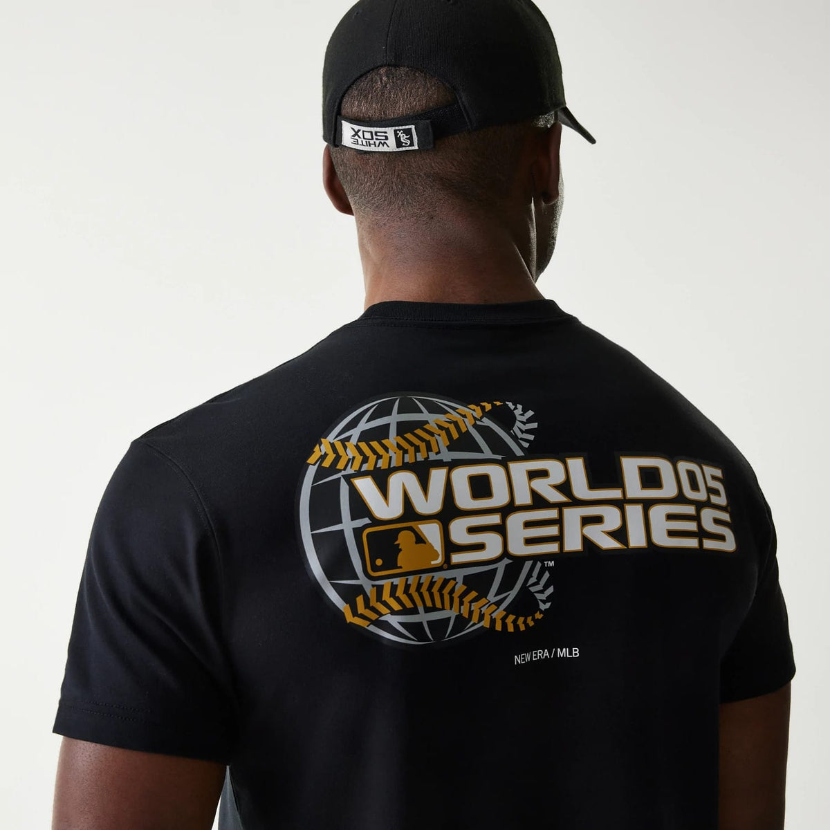 Chicago White Sox MLB 59FIFTY Pack Cloud Black T-Shirt, rear view showing a large World Series graphic with gold lettering and a baseball globe design, a New Era/MLB logo printed below, worn by a model in a black cap.
