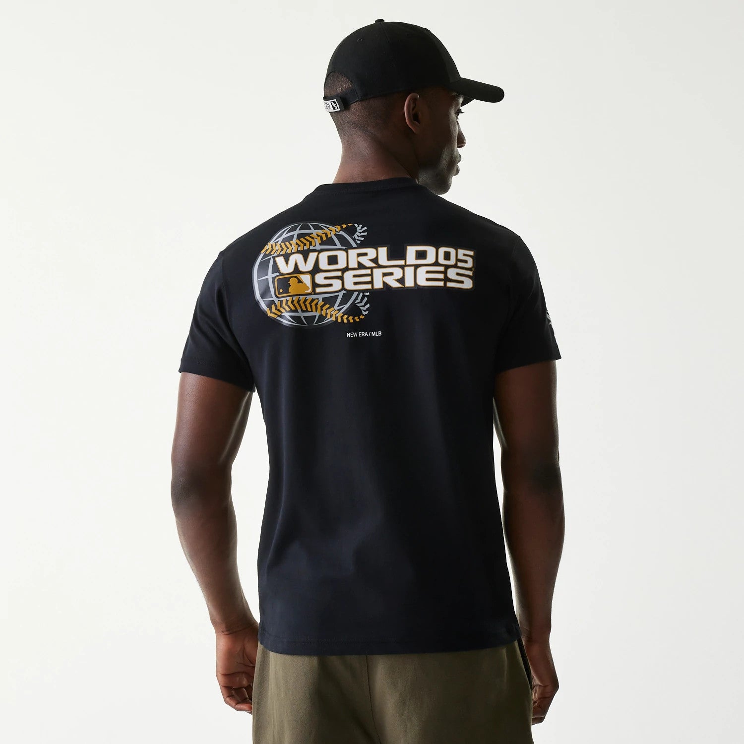 Chicago White Sox MLB 59FIFTY Pack Cloud Black T-Shirt, rear view displaying a bold World Series graphic with a globe design and white lettering, worn by a person also wearing a black cap with a debossed logo on the back.