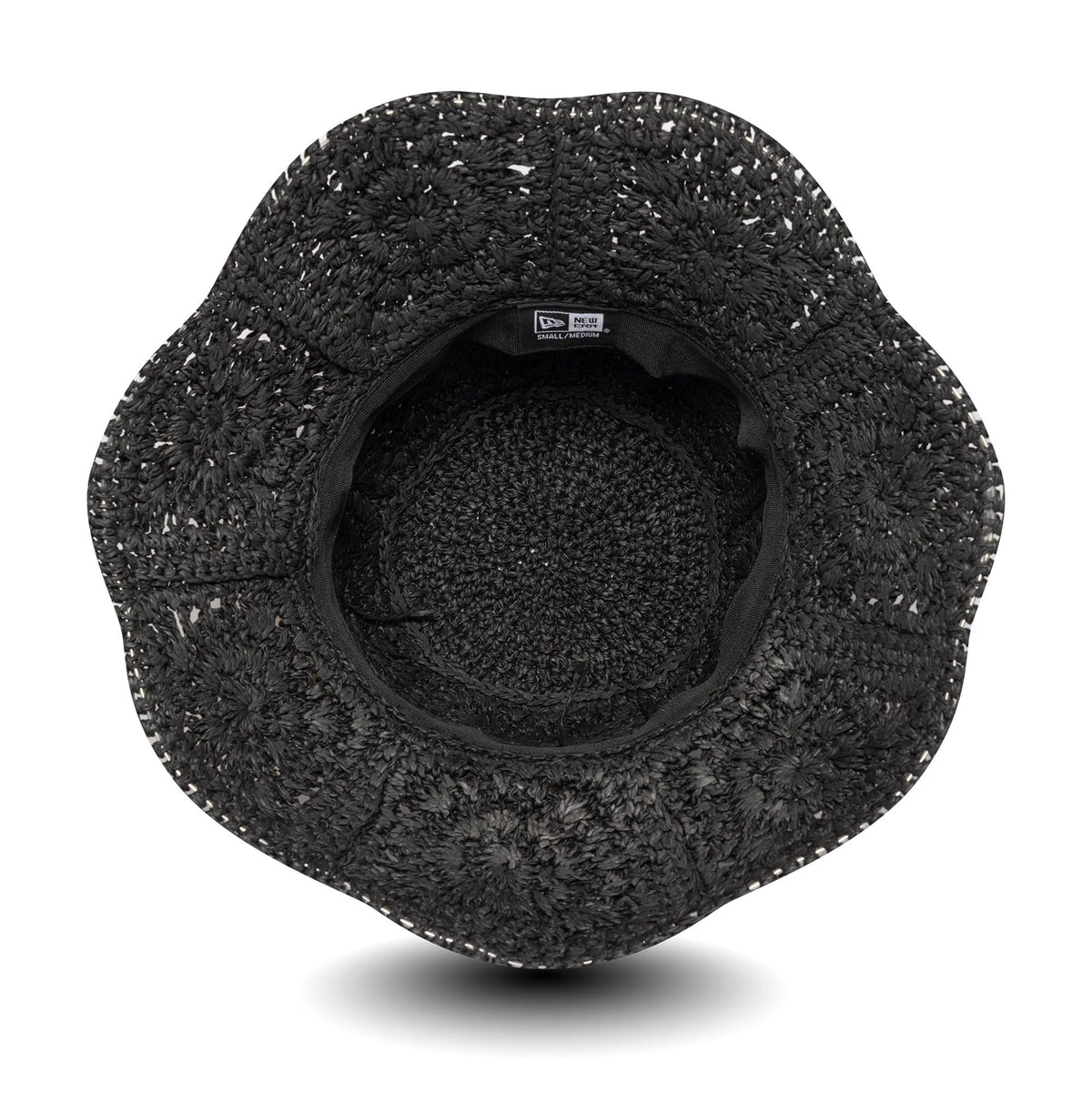 New Era Paper Hat Black Adventure Bucket Hat, inside view showing the intricate woven texture and black sweatband with a New Era label, the wide brim providing a distinct scalloped edge.
