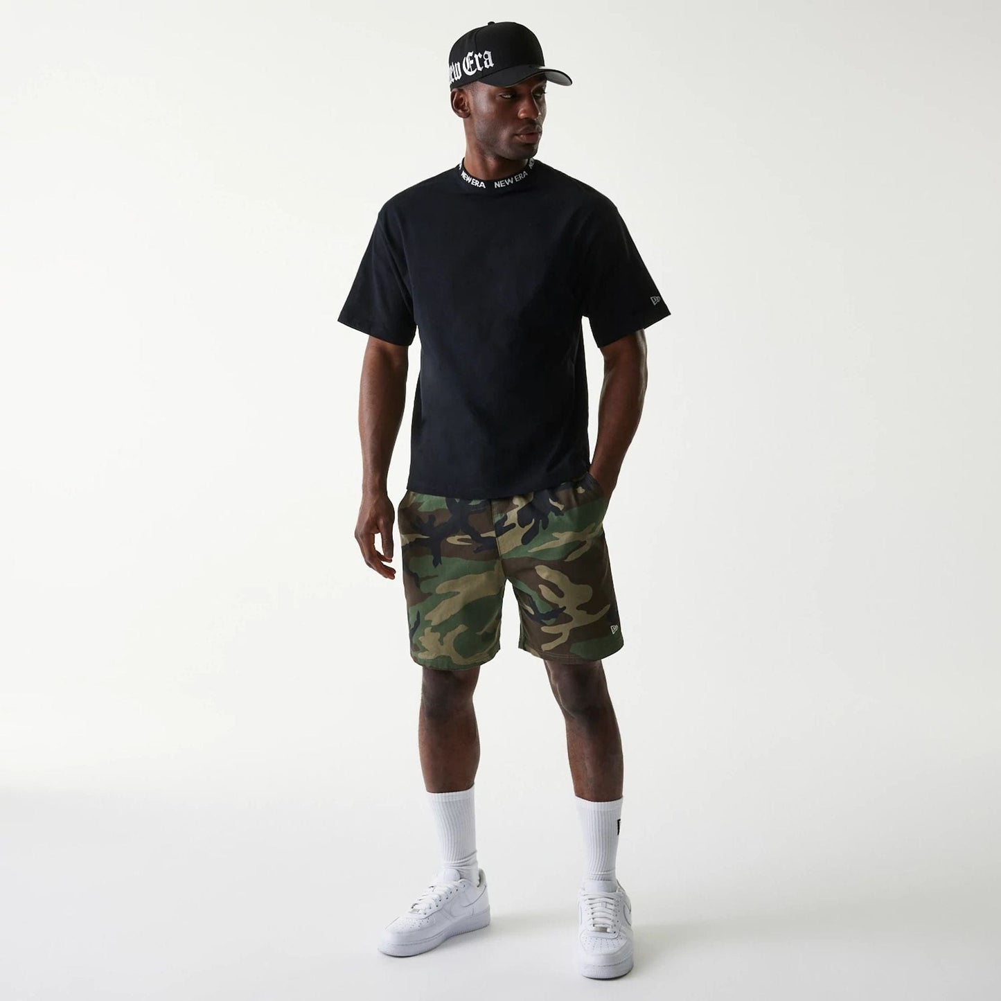 The Male model is wearing New Era Japan Neckband Logo Black T-Shirt 6