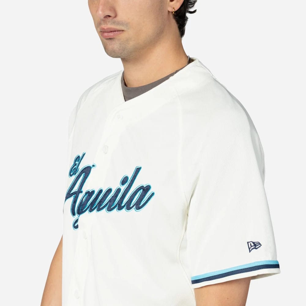 Veracruz Aguilas Mexico LMB On Field Cream On-Field Jersey, side view on a model with a New Era flag logo on the left sleeve and El Aguila script in blue with black outline across the chest.