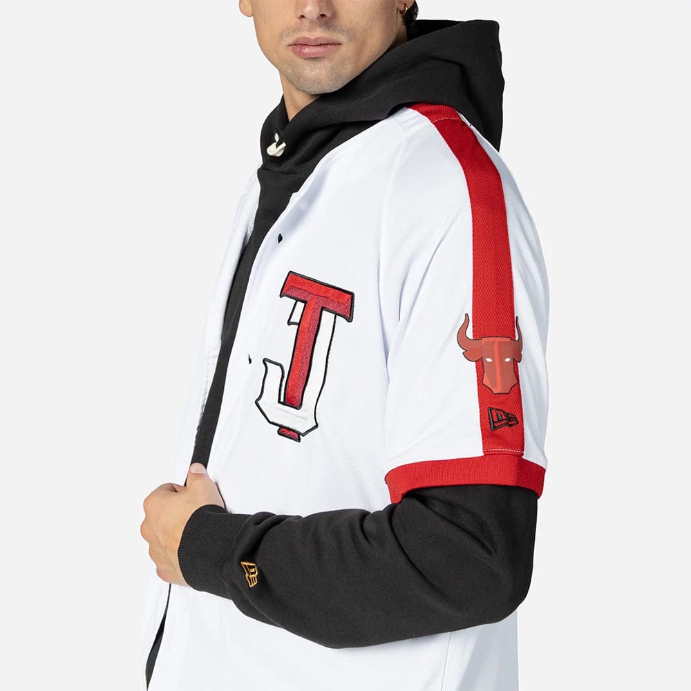 Tijuana Toros Mexico LMB On Field White On-Field Jersey, side view on a model wearing a black hoodie underneath, with a red bull logo on the sleeve and a prominent red J logo on the front.