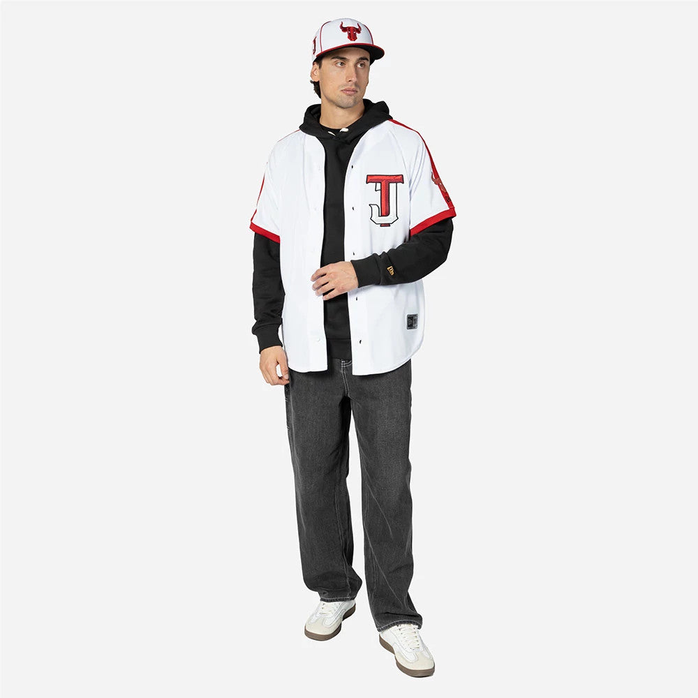 Tijuana Toros Mexico LMB On Field White On-Field Jersey, on-model view featuring black long-sleeve hoodie under the jersey, black and red cap with Tijuana Toros logo, with red trim on the jersey sleeves and hem.