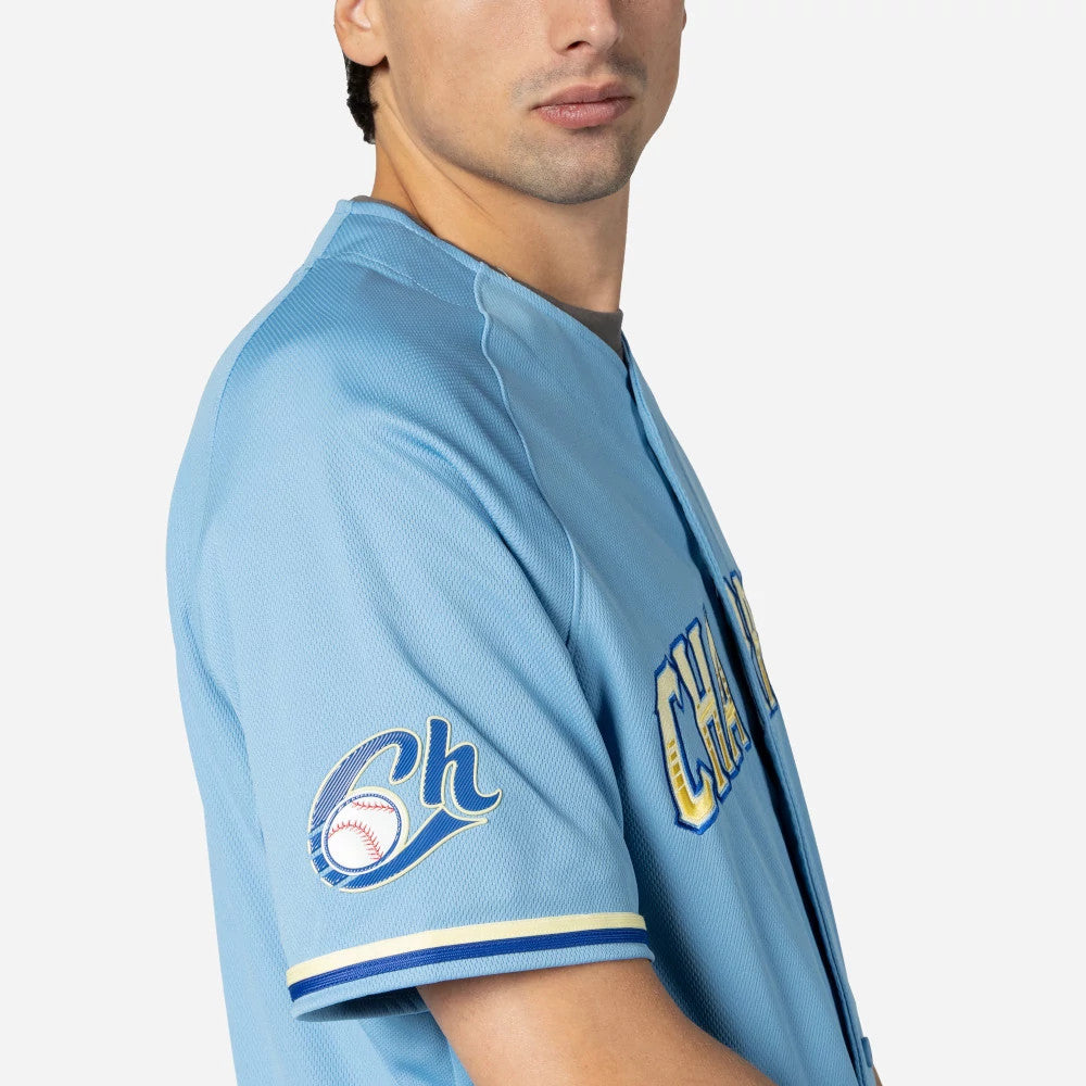 Charros De Jalisco Mexico LMB On Field Pastel Blue On-Field Jersey, side view on a model showing the embroidered Ch baseball logo on the left sleeve and the Charros lettering across the chest.