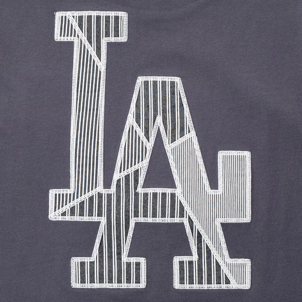 New Era LA Dodgers MLB Patchwork Grey T-Shirt, front view showing a large patchwork LA logo with white embroidered edges on a grey fabric, featuring different striped patterns within the letters.