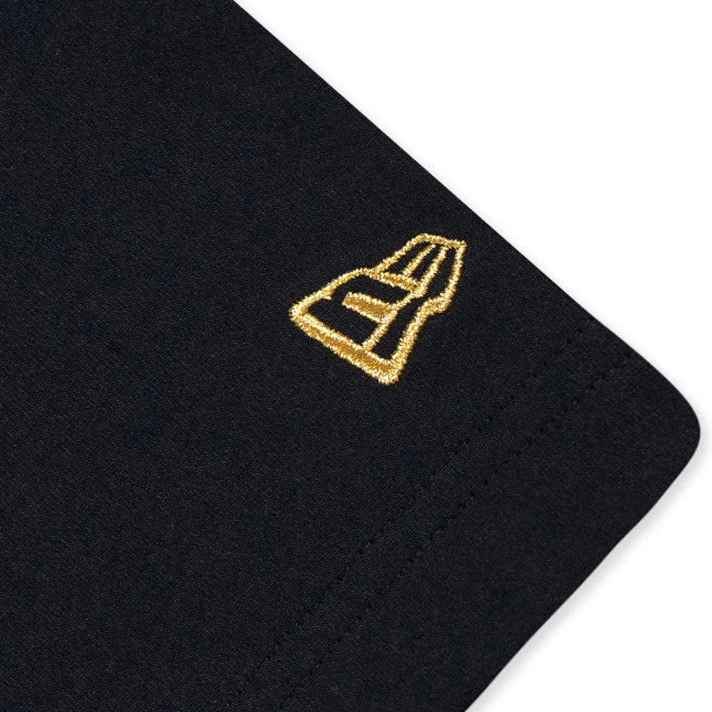New Era NEC logo Black T-Shirt, close-up view showing a gold embroidered New Era logo on the edge of the black sleeve, highlighting the simple and stylish detail on this classic T-shirt.