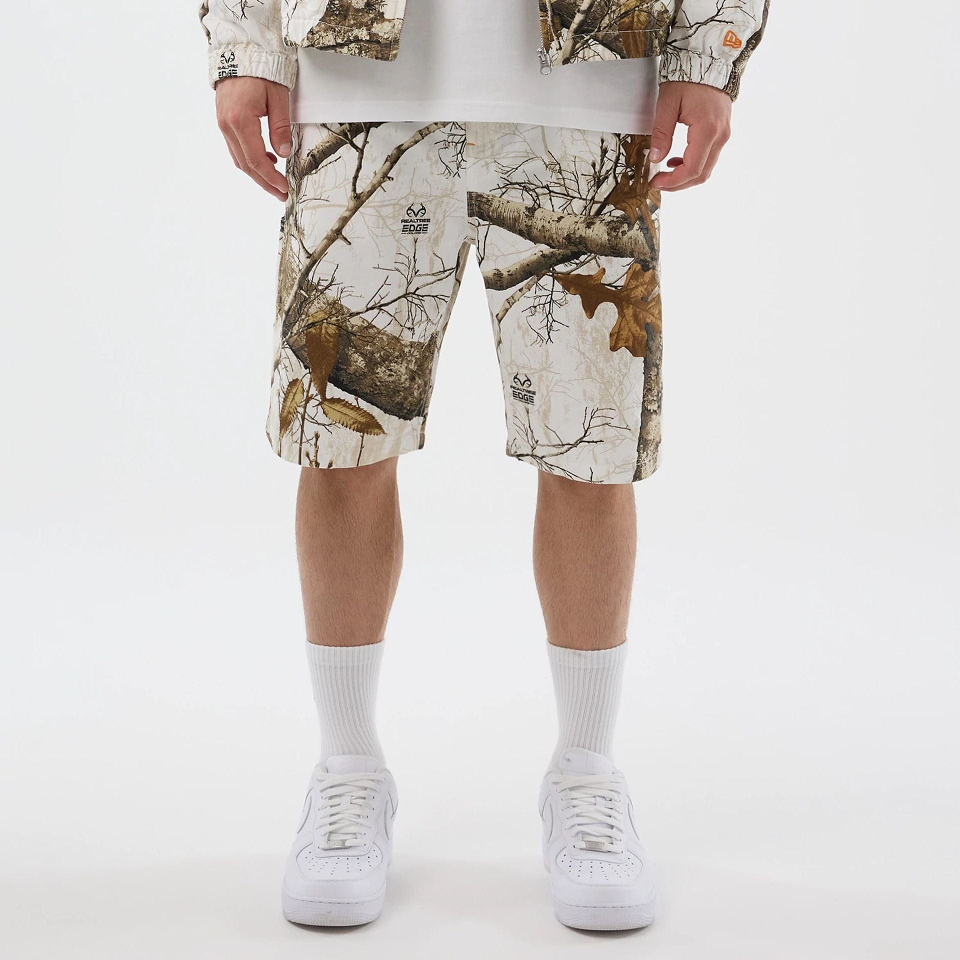 The Male model is wearing New Era Earthy Skin Real Tree Snow Oversized Shorts 1