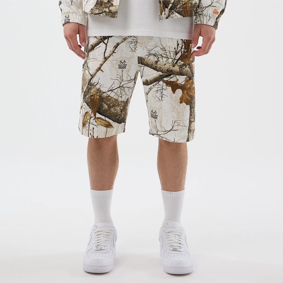 The Male model is wearing New Era Earthy Skin Real Tree Snow Oversized Shorts 1