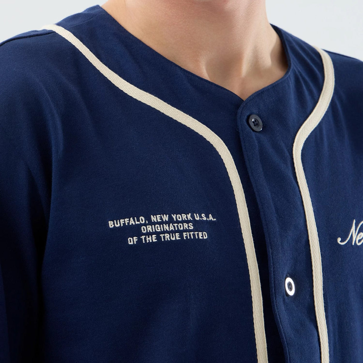 New Era Oceanside Blue Jersey, front view showing embroidered text "Buffalo, New York U.S.A. Originators of the True Fitted" on the left chest, with contrasting cream piping along the button placket.