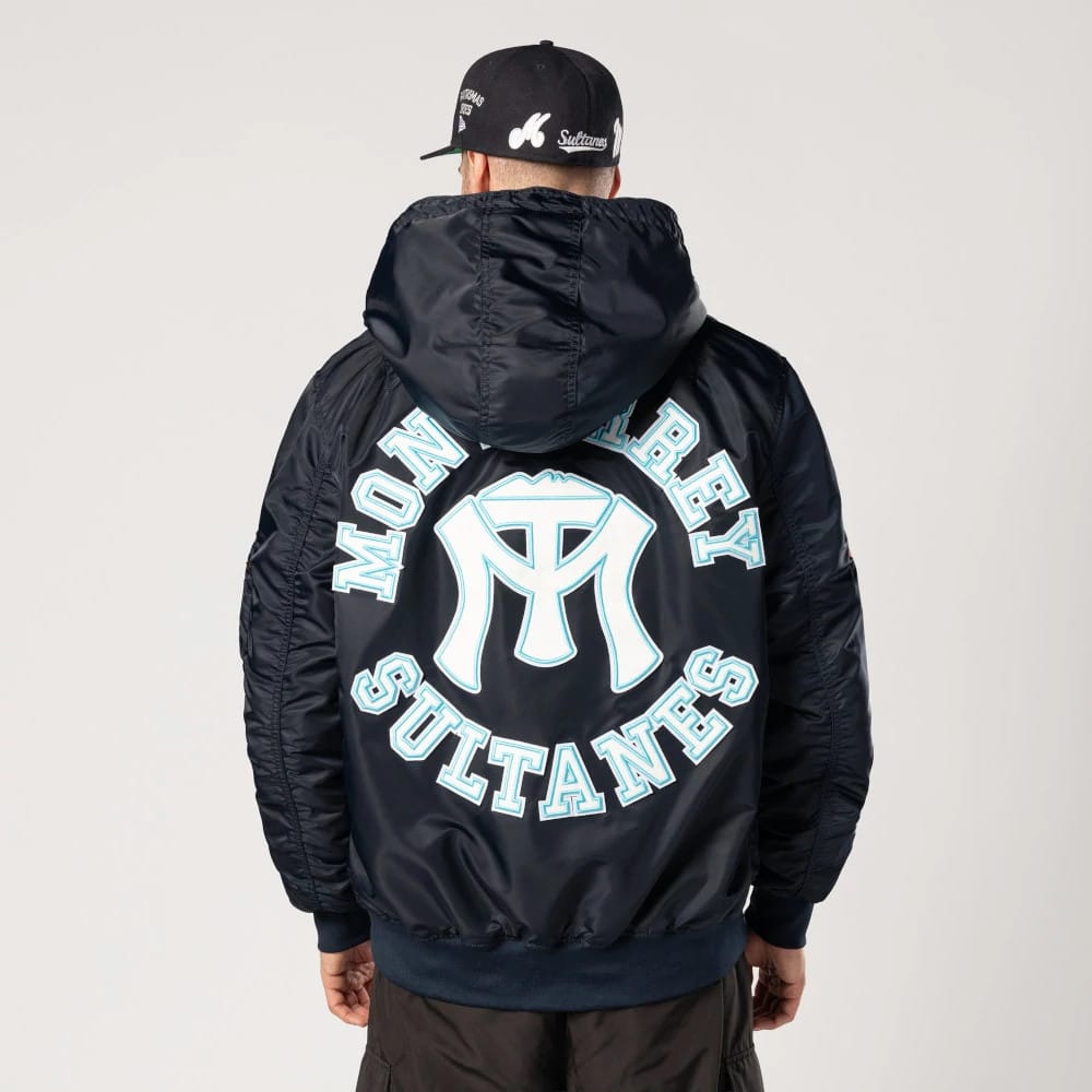 Sultanes De Monterrey LMB X Alpha Navy Jacket, rear view showing a large light blue Monterrey Sultanes logo centred on the back, contrasted against the navy fabric beneath a raised hood.