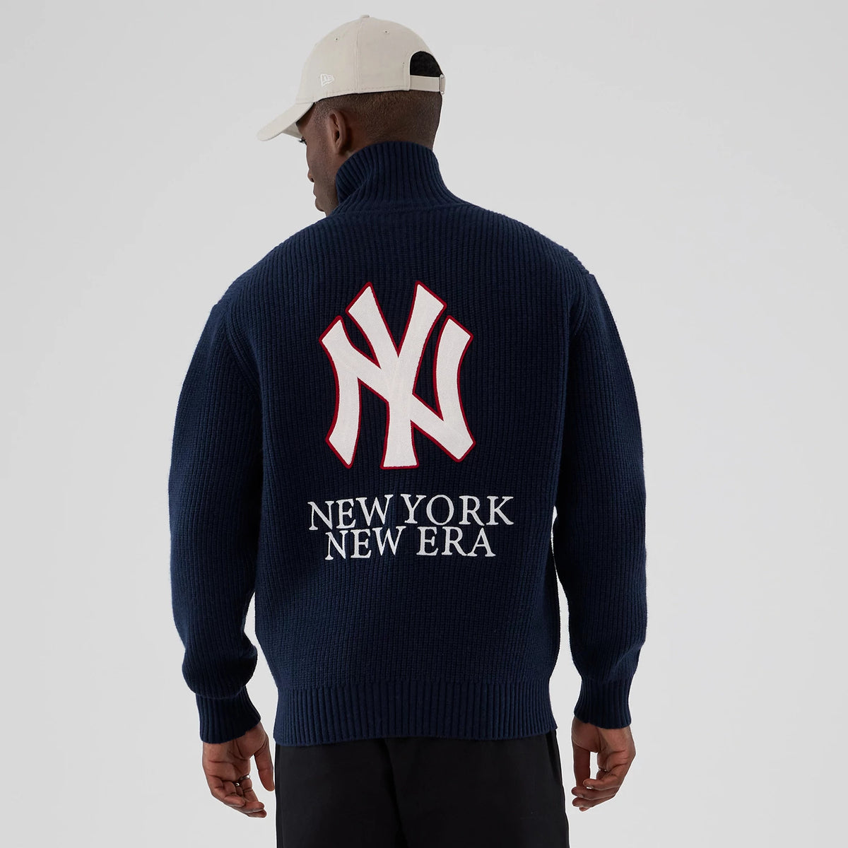 New York Yankees MLB Navy Cardigan, back view on a model, featuring a large white NY logo outlined in red above New York New Era lettering, with a high collar and ribbed knit texture.