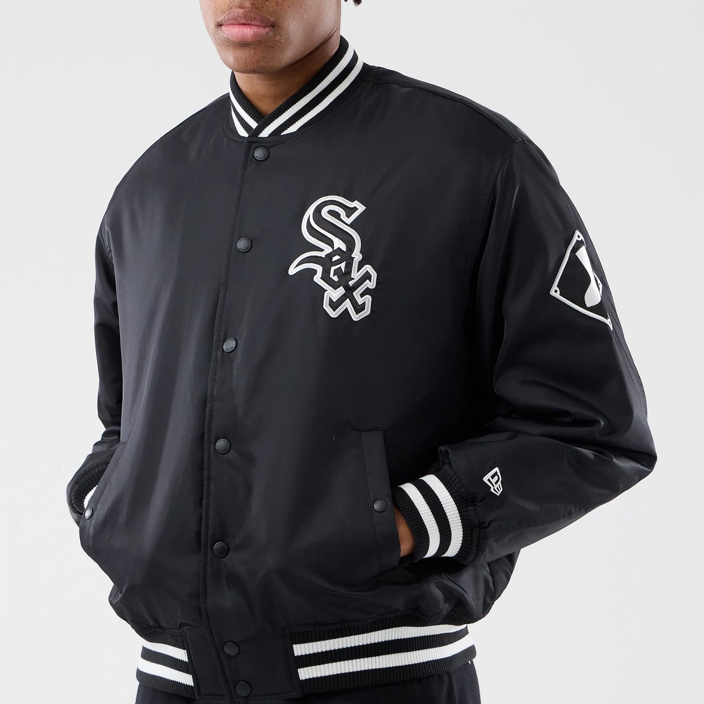 Chicago White Sox MLB Authentic Black Stadium Jacket, front view showing the embroidered white Sox logo on the chest, black shell with contrasting black and white ribbed collar and cuffs, and New Era logo on the left sleeve.