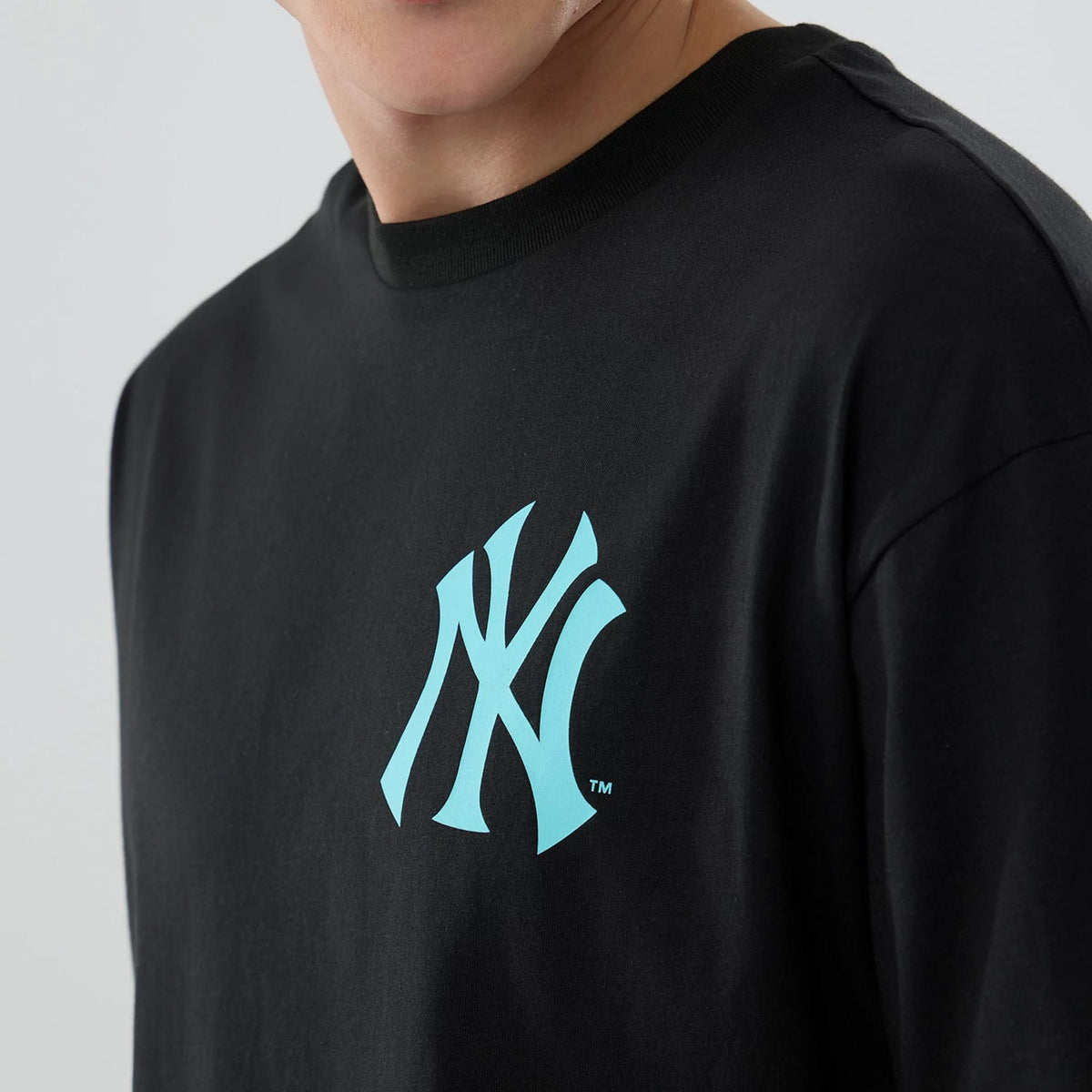 New York Yankees MLB Neon Light Black T-Shirt, front view showing a raised aqua New York Yankees logo positioned on the left chest of the black T-shirt with a crew neck and short sleeves.