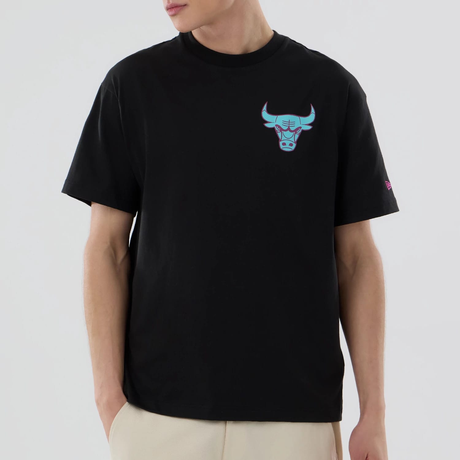 Chicago Bulls NBA Neon Light Black T-Shirt, on-model view featuring a neon-effect Bulls logo on the left chest and a small purple New Era logo embroidered on the left sleeve, all set against a plain black fabric.