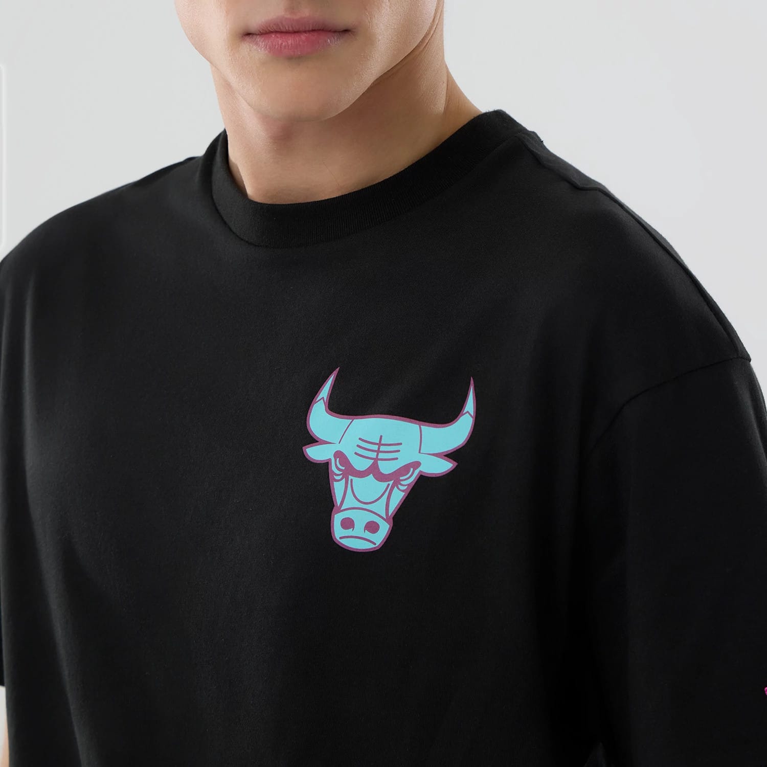 New Era Chicago Bulls NBA Neon Light Black T-Shirt, front view showing the black fabric with a neon light style bull logo printed on the left chest area, featuring bright blue and pink accents on the design.