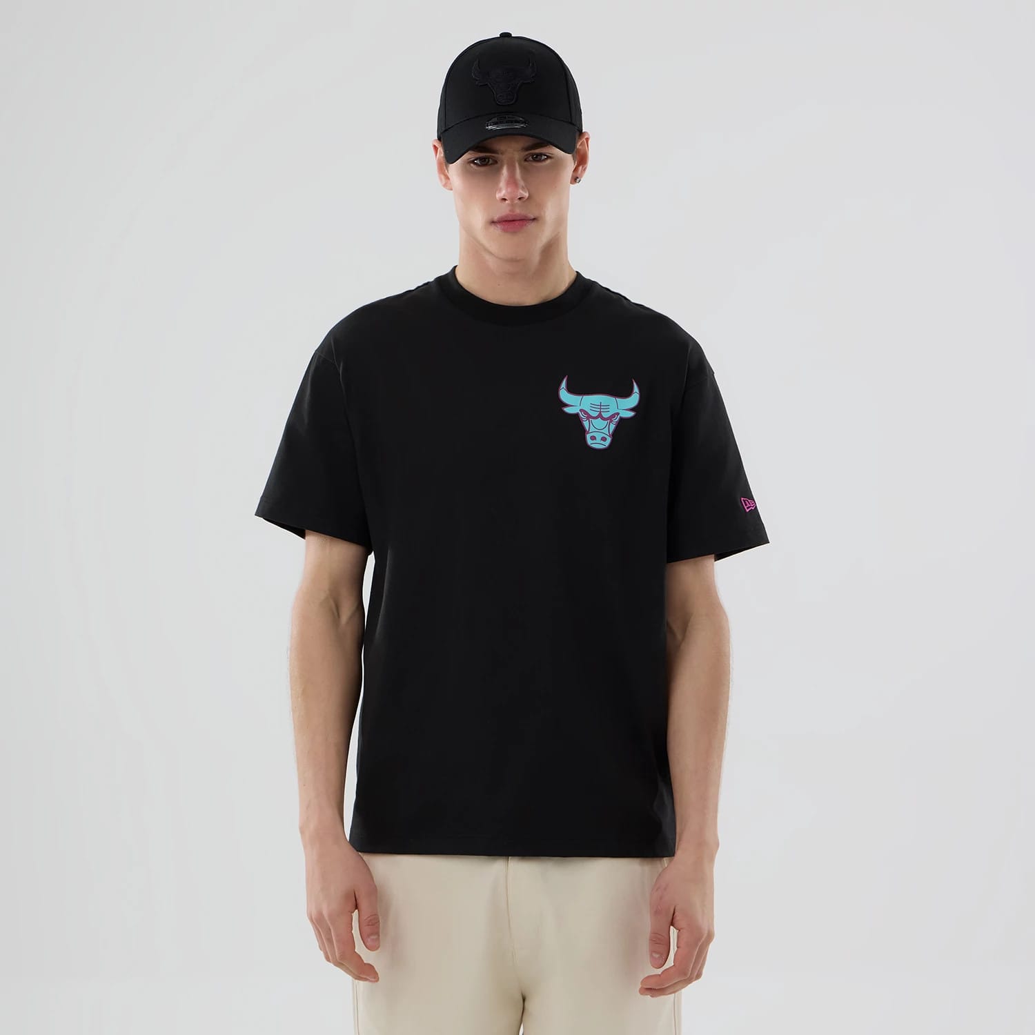 Chicago Bulls NBA Neon Light Black T-Shirt, on-model front view showing a bold neon-style bull logo on the chest, a small embroidered New Era logo on the sleeve, and the plain black fabric of the T-shirt against the light background.