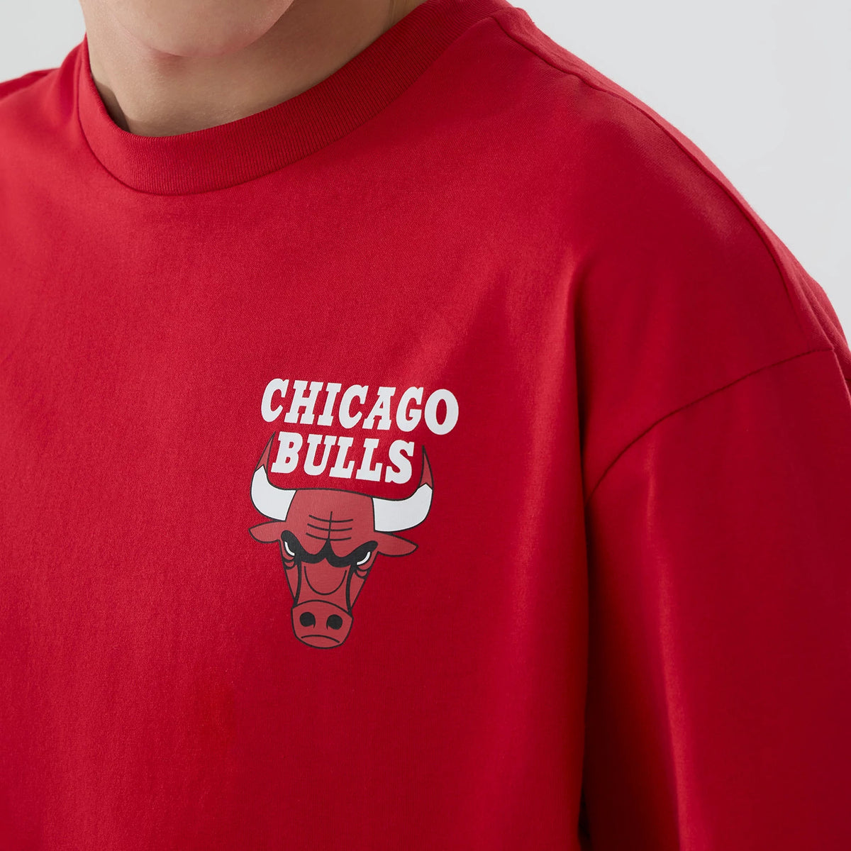Chicago Bulls NBA logo Red T-Shirt, front view showing the bold white text "Chicago Bulls" above a printed image of the team's iconic bull logo on the left chest of the vibrant red fabric.