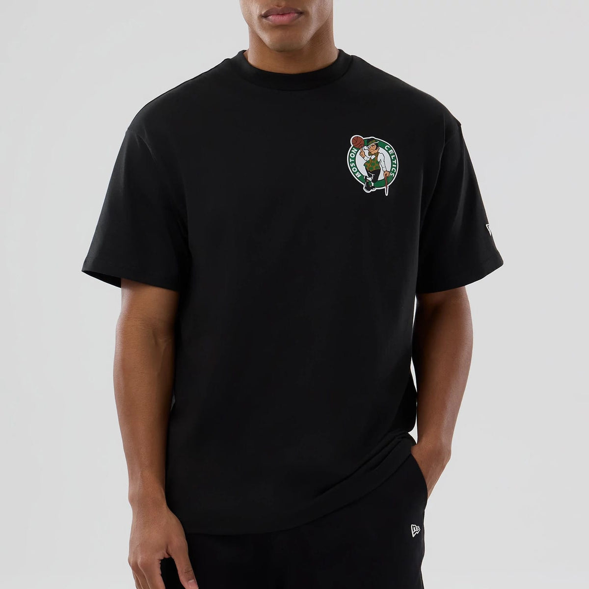 Boston Celtics NBA logo Black T-Shirt, front view showing the black short-sleeve shirt with a Boston Celtics logo on the left chest and a small debossed New Era logo on the left sleeve.