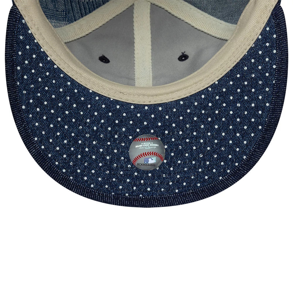 New York Mets MLB Multi Denim Dark Blue Retro Crown New Era 9FIFTY Adjustable Cap, inside view showing polka dot dark blue undervisor, cream sweatband, curved taping, and a baseball-themed sticker centred on the underside of the visor.