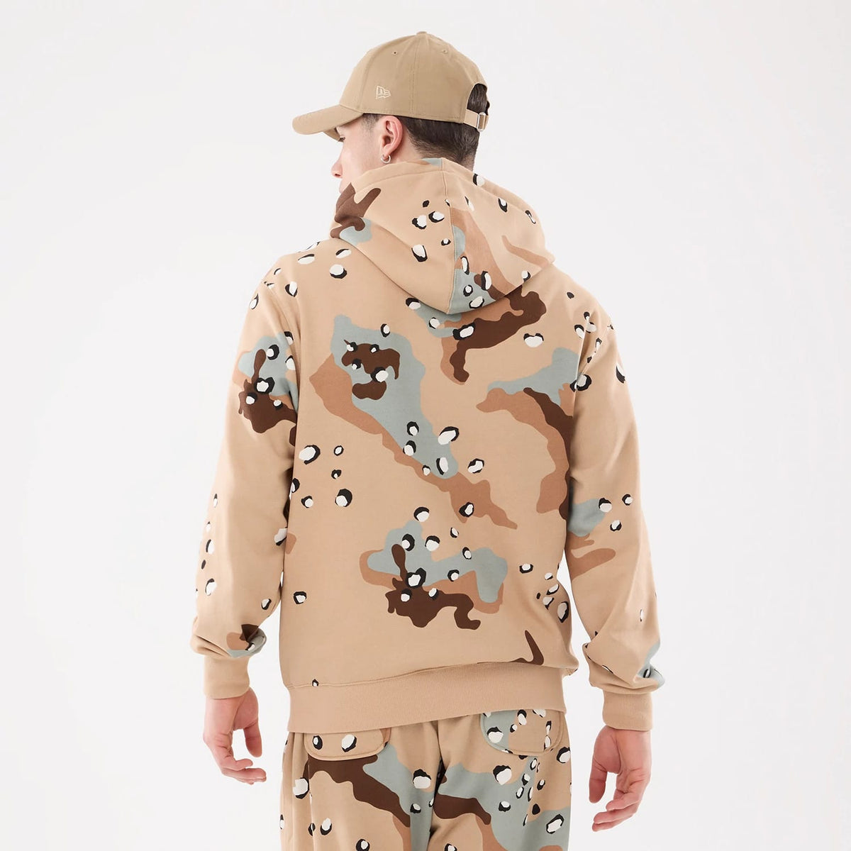 New York Yankees MLB Desert Camo 2 Way Full Zip Hoodie, rear view showing a desert camo pattern in shades of beige, brown, and grey with a raised New Era logo on the side of a beige cap worn by a model.