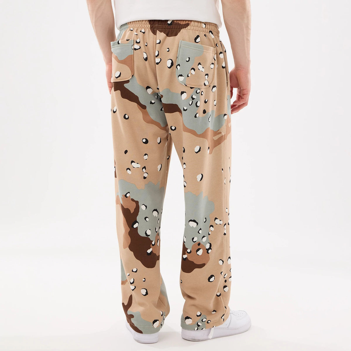 New Era Desert Camo Joggers, rear view on a model wearing a white T-shirt, showing the distinctive multi-tone camouflage pattern, elasticated waistband, and two back pockets on the relaxed-fitting trousers.