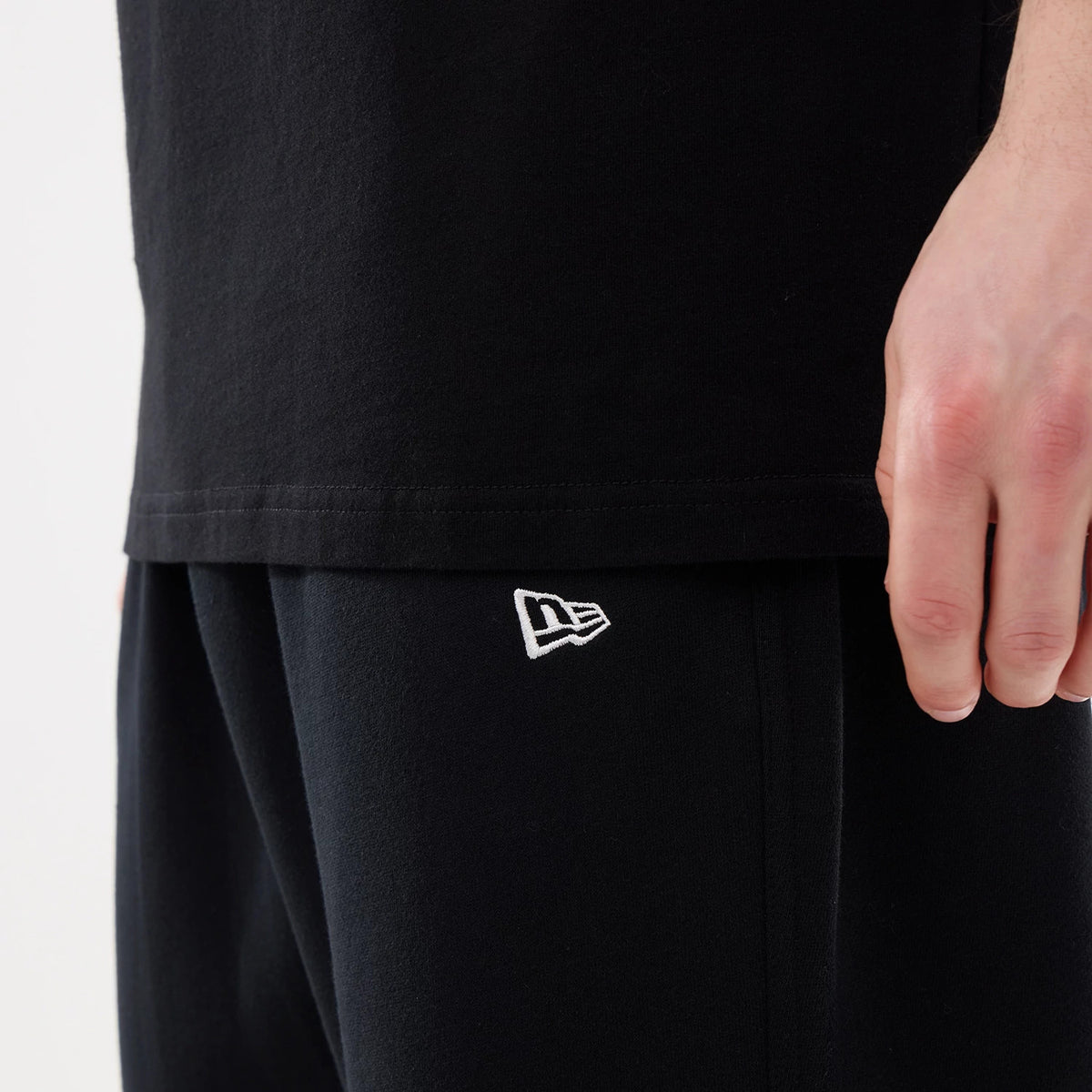 New Era New York Mets MLB Comfort Black Joggers, close-up showing the New Era flag logo embroidered in white on the left leg, worn with a black t-shirt, highlighting the soft fabric and relaxed fit of the joggers.