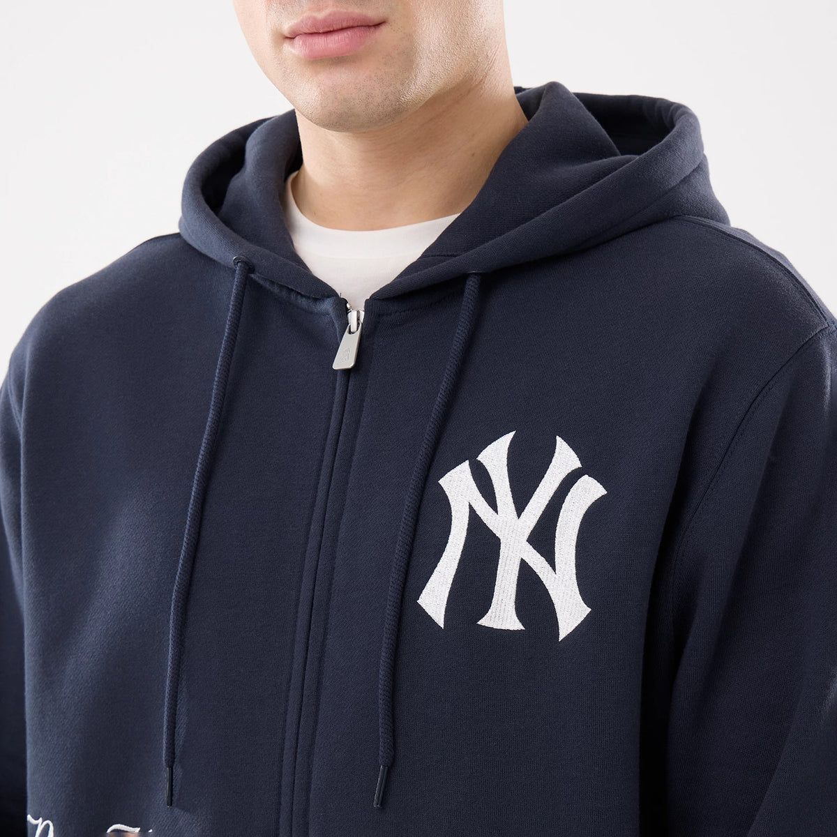 The model is wearing this MLB Comfort New York Yankees 2 Way Full Zip Hoodie in navy. 4