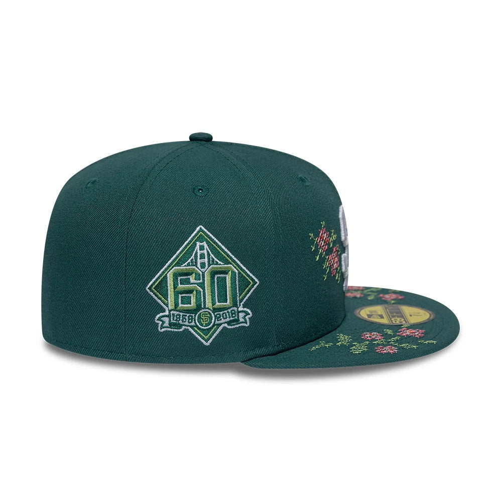 San Francisco Giants MLB Garden Dark Green New Era 59FIFTY Fitted Cap, side view showing a green 60th anniversary logo on the left side of the crown and floral embroidery on the dark green visor with a gold 59FIFTY size sticker.
