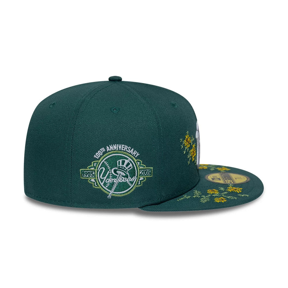 New York Yankees MLB Garden Dark Green New Era 59FIFTY Fitted Cap, side view with a white and green embroidered 100th Anniversary logo on the front panel and floral embroidery on the visor, featuring a gold 59FIFTY size sticker.