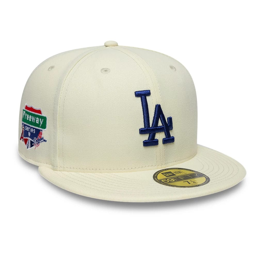 LA Dodgers MLB City Series White New Era 59FIFTY Fitted Cap, front view showing raised blue LA logo on front panel, Freeway Series patch on the side, white top button, and gold 59FIFTY size sticker on the flat visor.