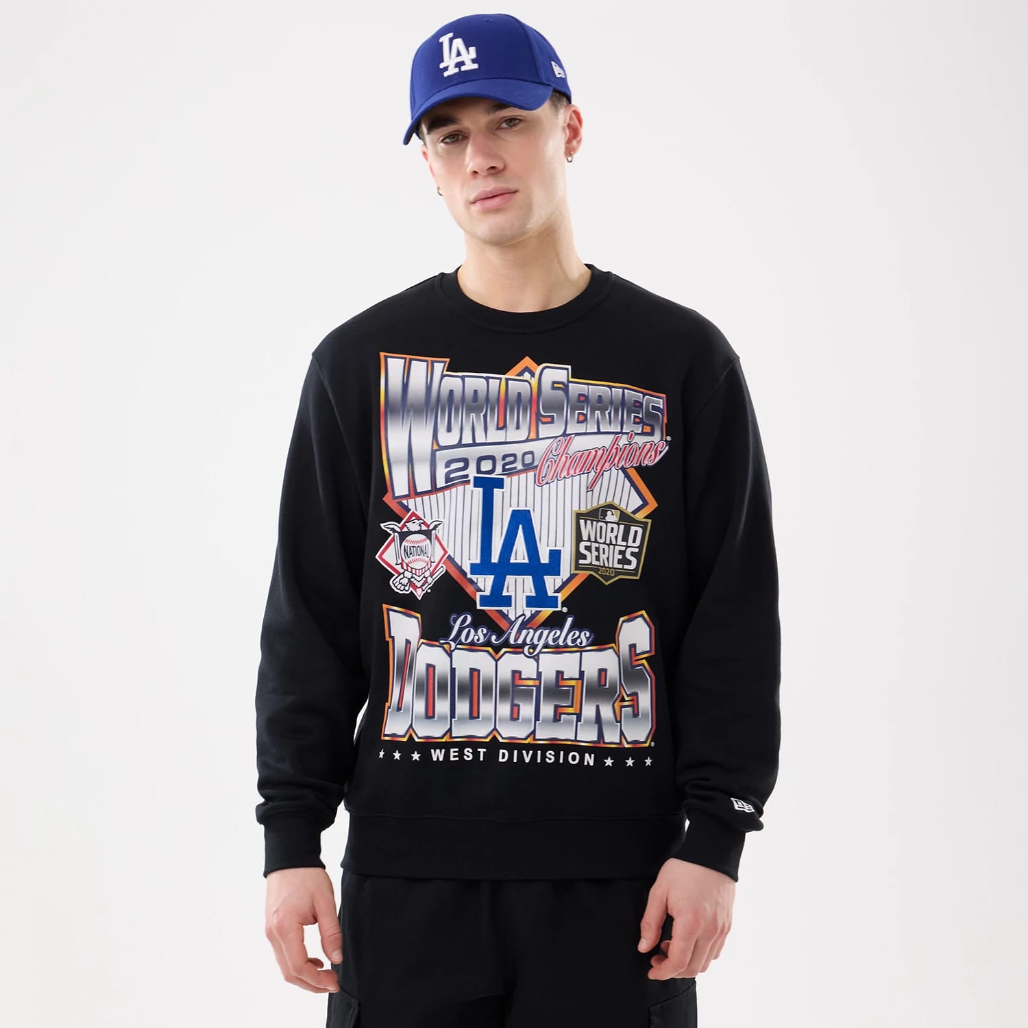 LA Dodgers MLB Retro Black Oversized Crew Neck Sweater, front view on a model with a blue LA cap, featuring bold graphic design with World Series 2020 Champions lettering and team logos across the chest.