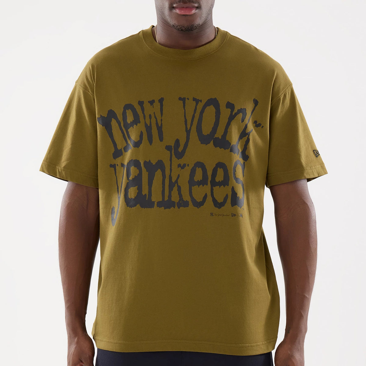 New York Yankees MLB Green T-Shirt, front view showing the oversized black distressed "new york yankees" text across the chest and a small debossed New Era logo on the left sleeve.