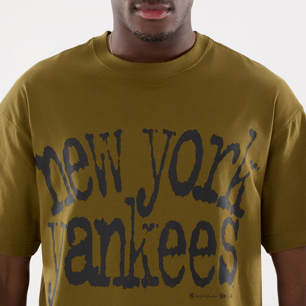 New York Yankees MLB Green T-Shirt, front view showing a large black New York Yankees text across the chest, with a small embroidered New Era logo in black near the bottom hem on the left side.