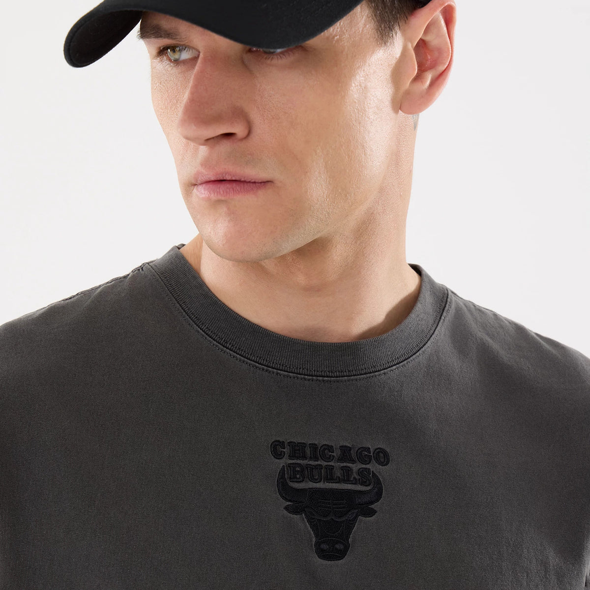 New Era Chicago Bulls NBA Shadow Pop Black T-Shirt, on-model view showing the embossed Chicago Bulls logo centrally placed on the chest with the greyish-black fabric and a rounded neckline.