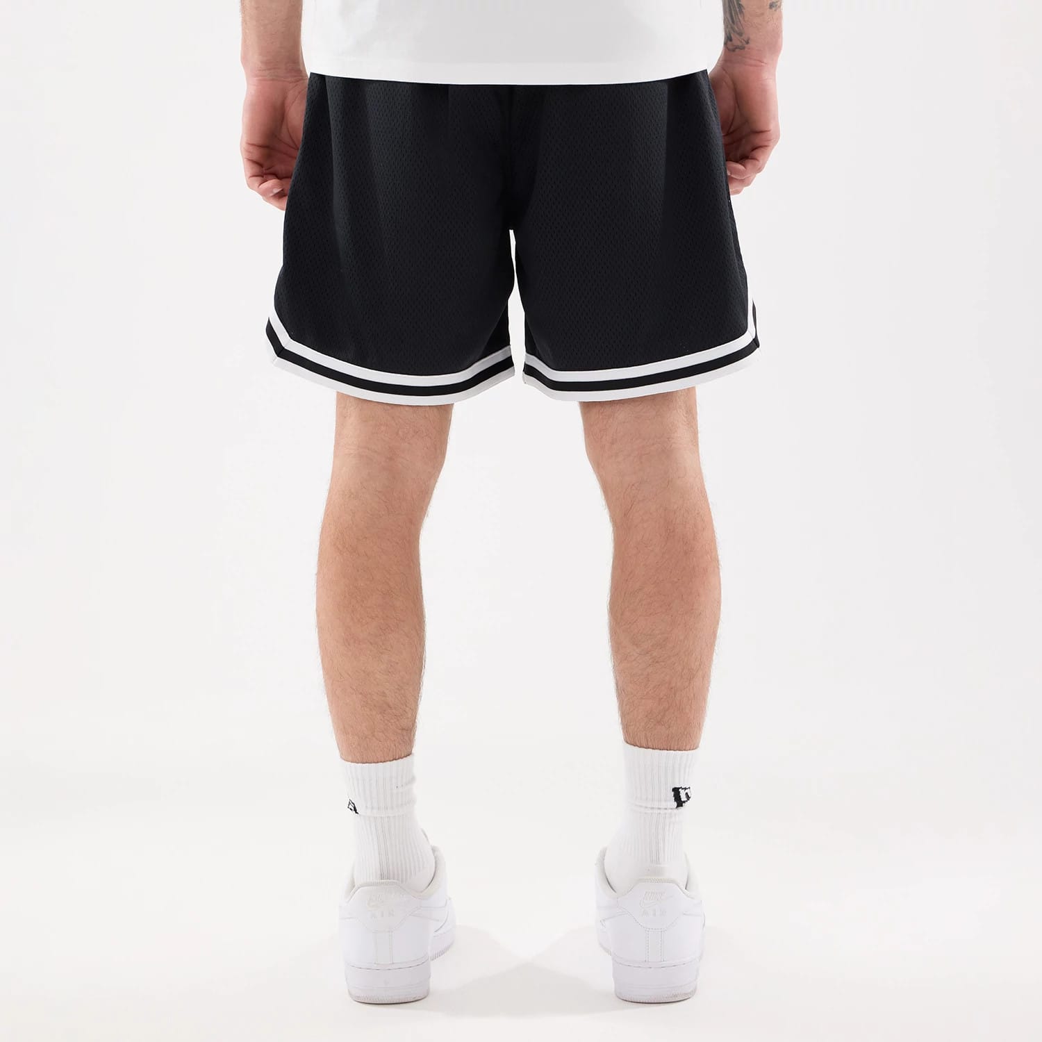 New Era New York Mets MLB Comfort Navy Oversized Shorts, rear view showing the loose fit with navy fabric and white trim along the hem, worn on-model with white socks and trainers.