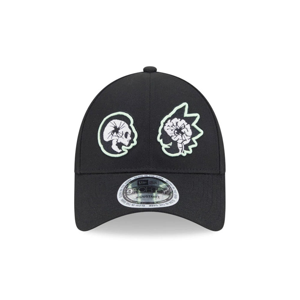 Rick And Morty Glow In The Dark Black New Era 9FORTY Adjustable Cap, front view showing white skull and brain logos with glow green outlines embroidered on the black crown, with a 9FORTY size sticker on the visor.