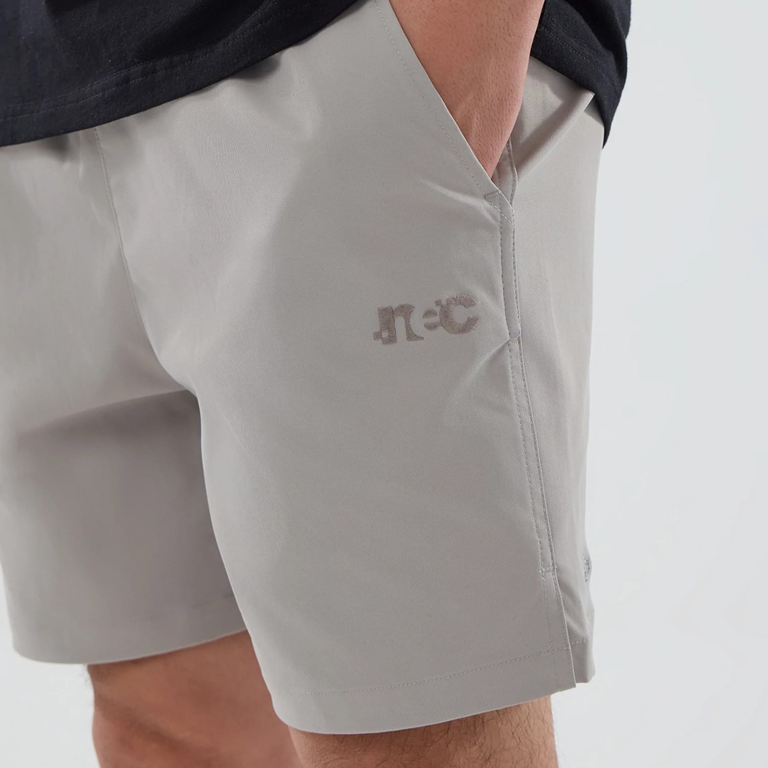 The model is wearing this New Era NEC Logo Oversized Shorts in Beige . 2