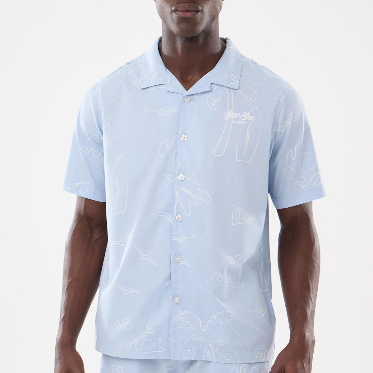 The model is wearing this New Era Resort Short Sleeve Shirt in blue. 3
