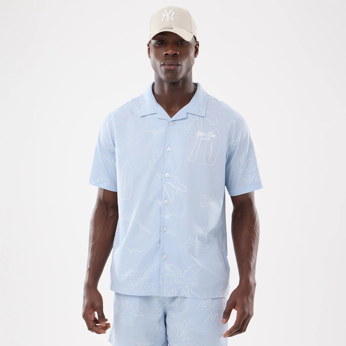 The model is wearing this New Era Resort Short Sleeve Shirt in blue. 1