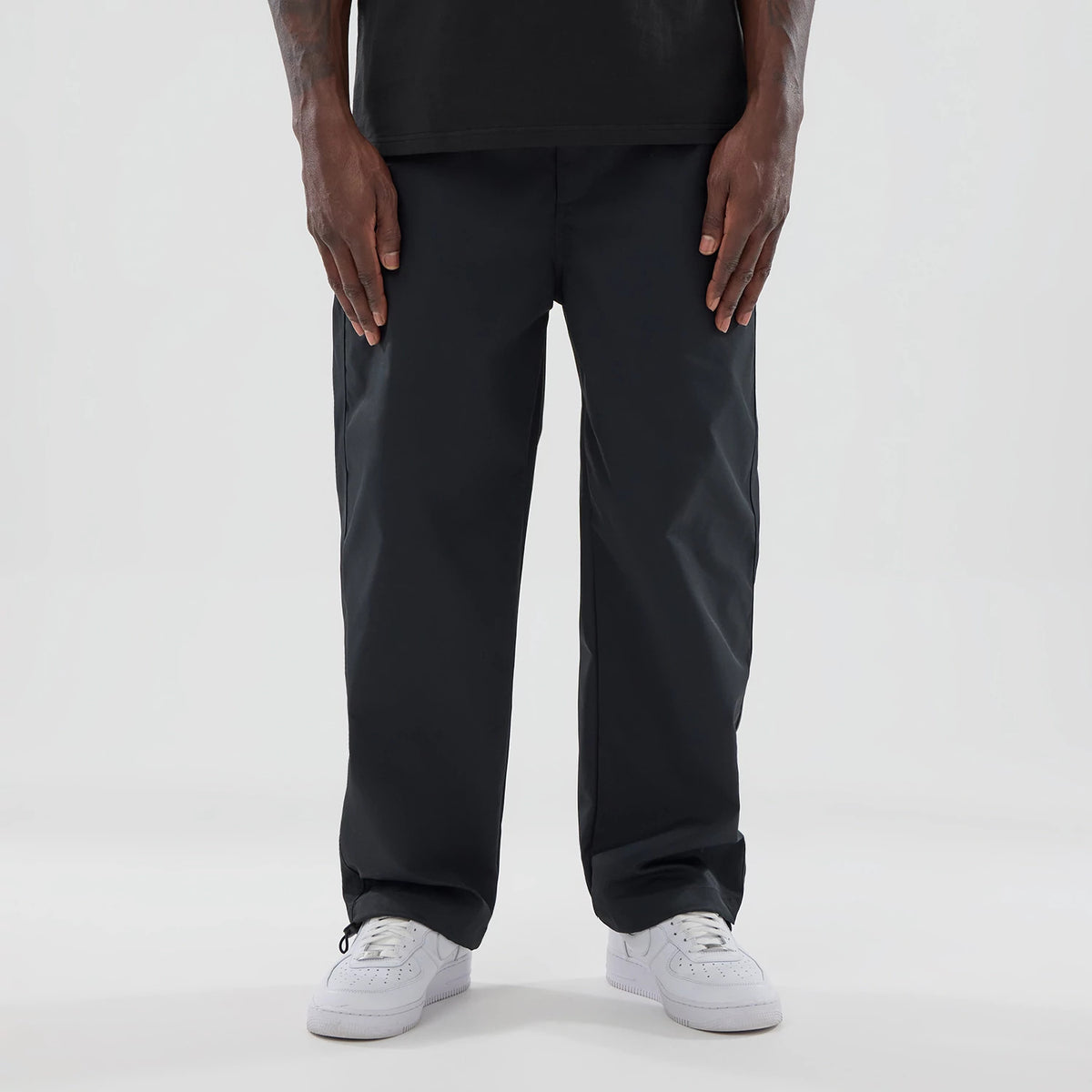 The model is wearing this New Era NEC Logo Straight Leg Joggers in black. 1