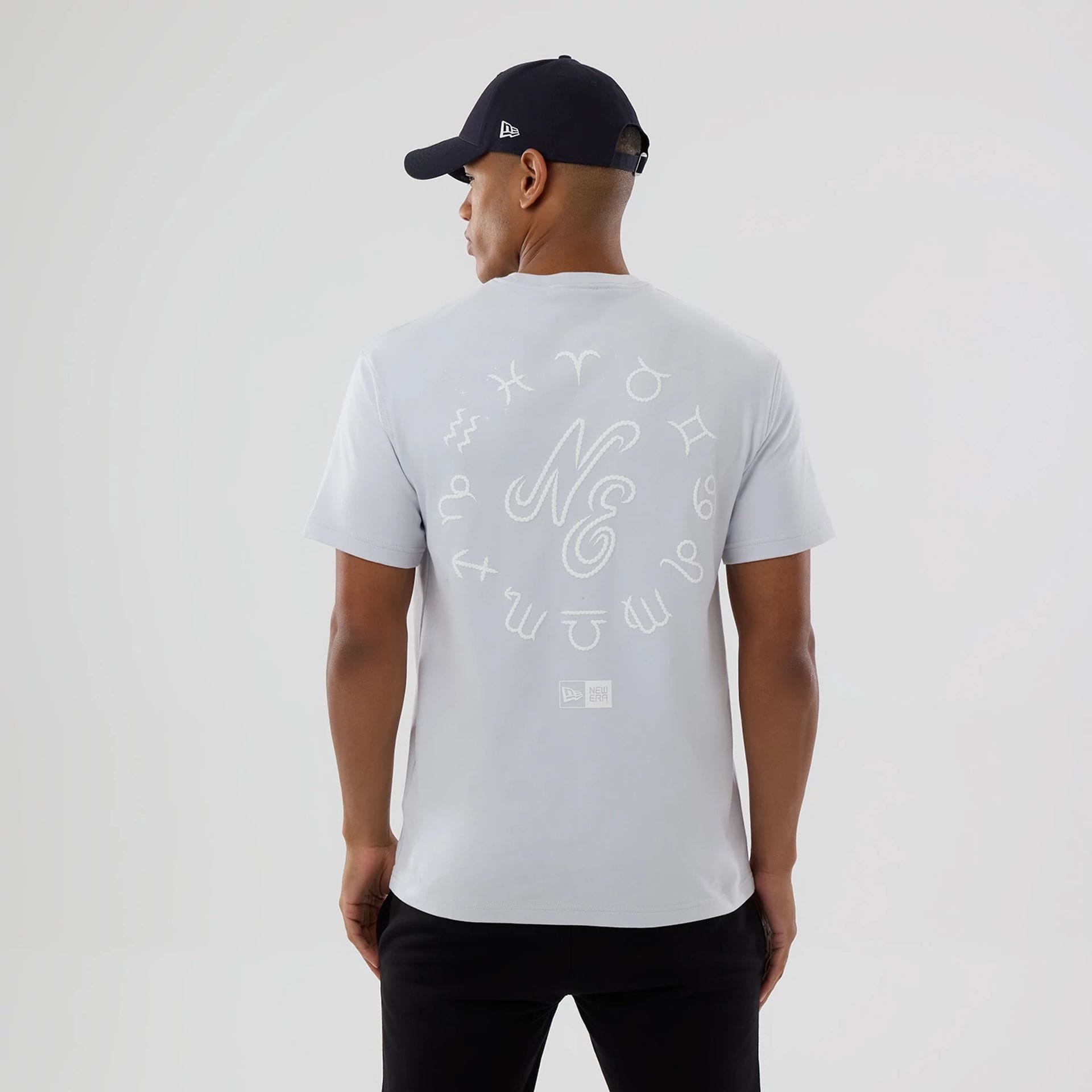 The model is wearing this New Era Zodiac Sign T-Shirt in silver. 2