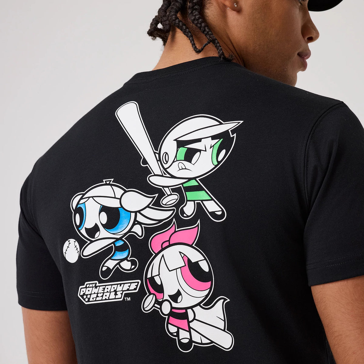 Powerpuff Girls Powerpuff Girls Black T-Shirt, rear view showing colourful cartoon characters printed on the back, including Bubbles, Buttercup, and Blossom with a bat, and the Powerpuff Girls logo in white near the bottom left corner.
